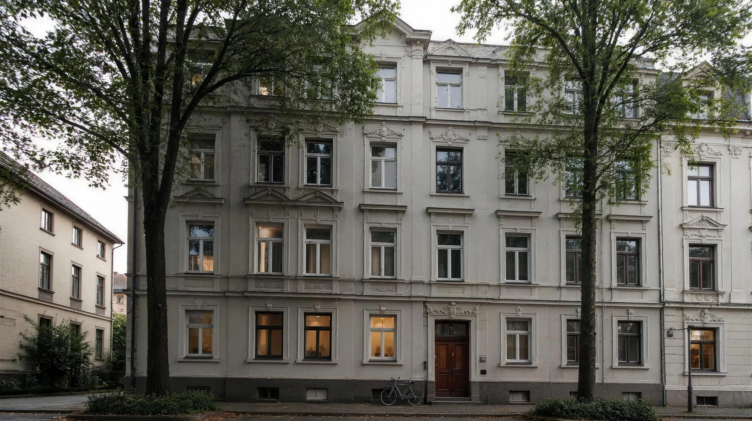 Vierstöckiges Gründerzeit-Mietshaus mit Stuckfassade an einer ruhigen Straße (Symbolbild)