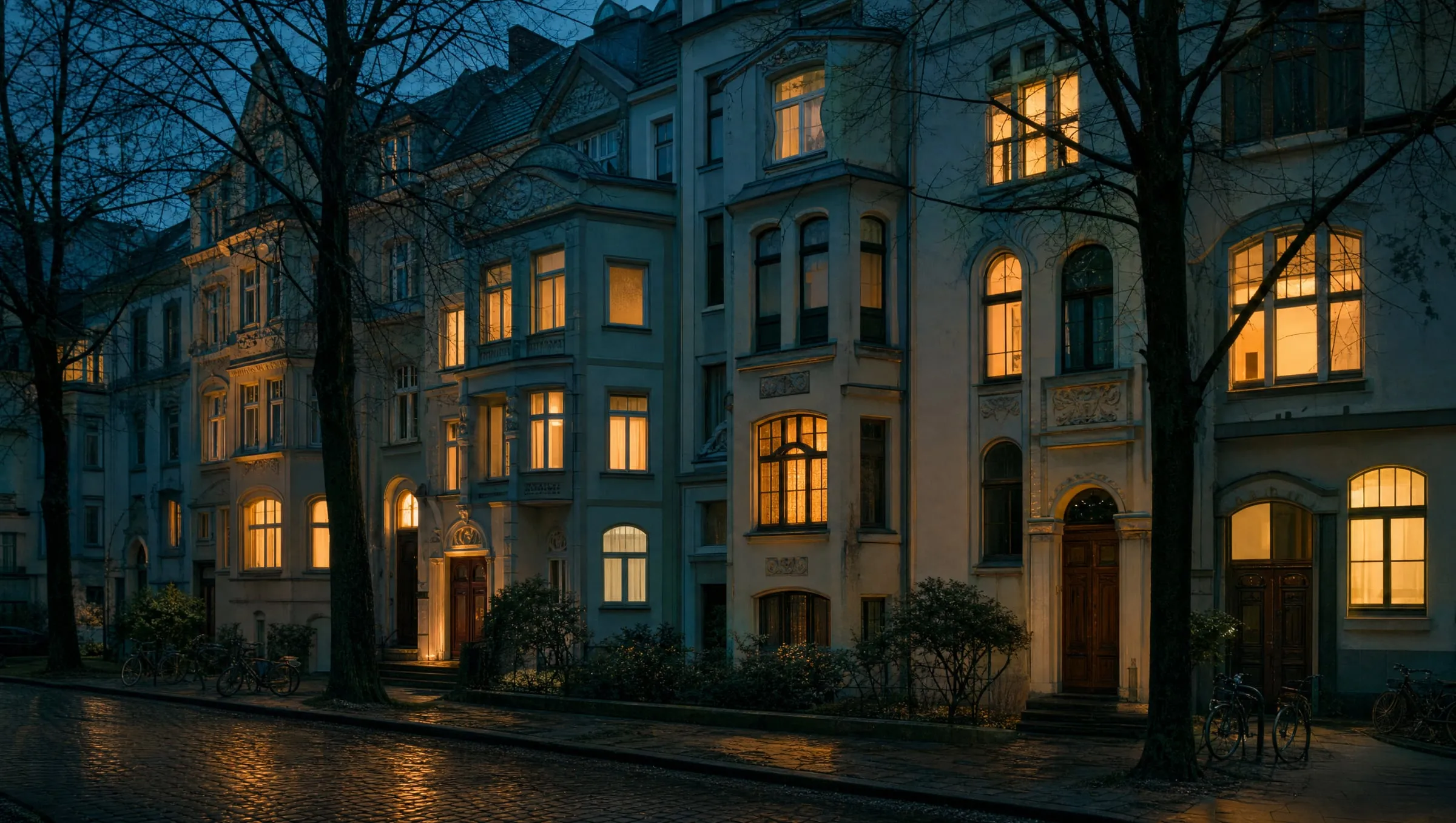 Straße mit Gründerzeithäusern am Abend, einzelne Fenster erleuchtet (Symbolbild)